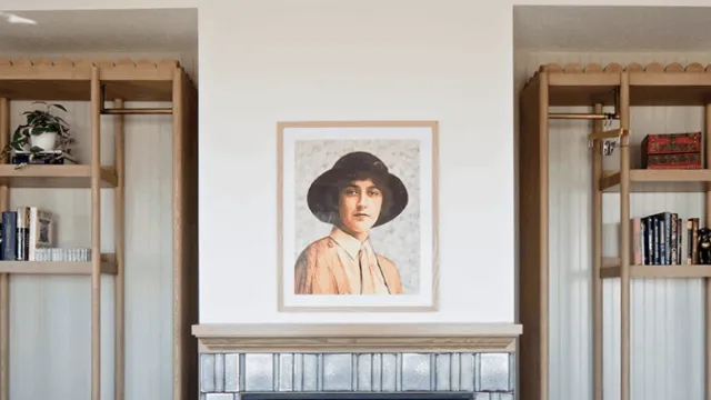 A cozy living room with a central fireplace, built-in wooden shelves, and a framed portrait above the mantel, balanced by two matching bookcases.